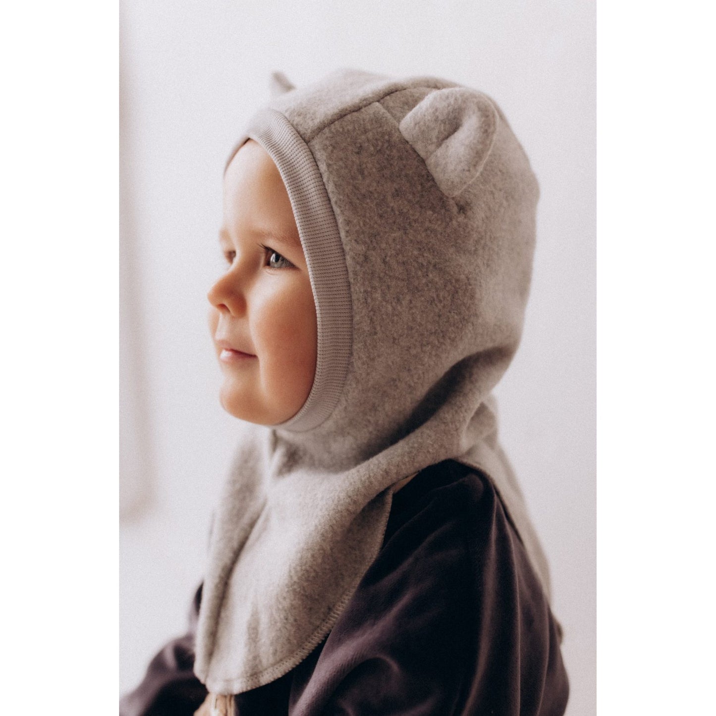 Wooly Organic balaclava in licht taupe, profiel van jongen met capuchon om hoofd en nek