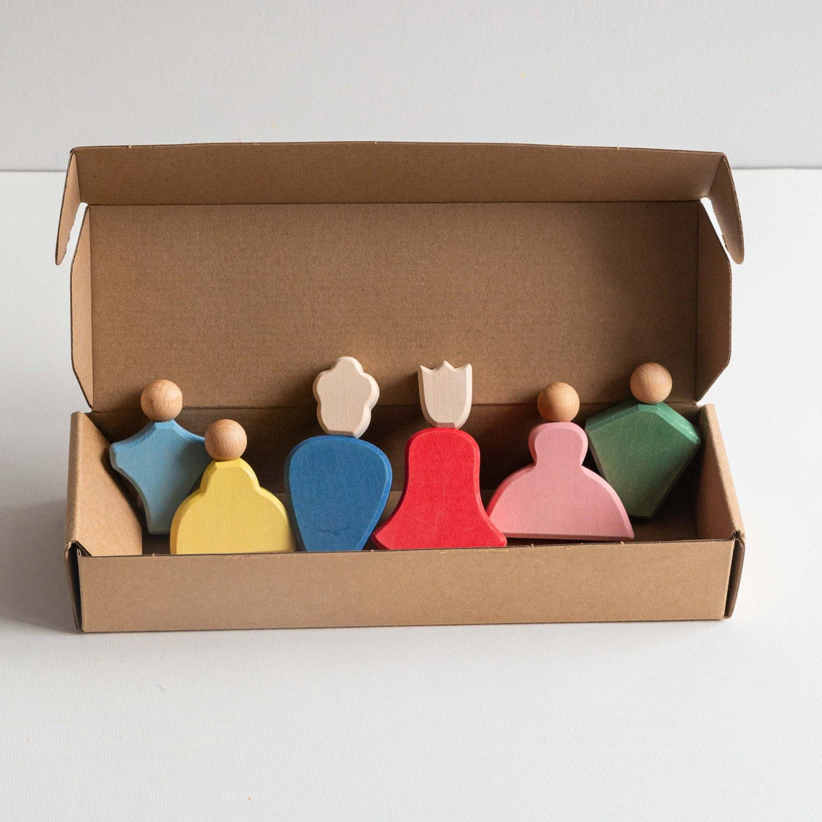 Avdar Fairytale Family speelset: zes houten poppeties in kartonnen doos, bovenaanzicht met kleurrijke figuren