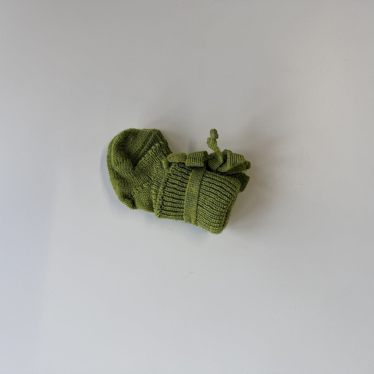 Hirsch Natur newborn sokjes in limegroen, uitgespreid op wit oppervlak, bovenaanzicht met details van ribbelpatroon zichtbaar
