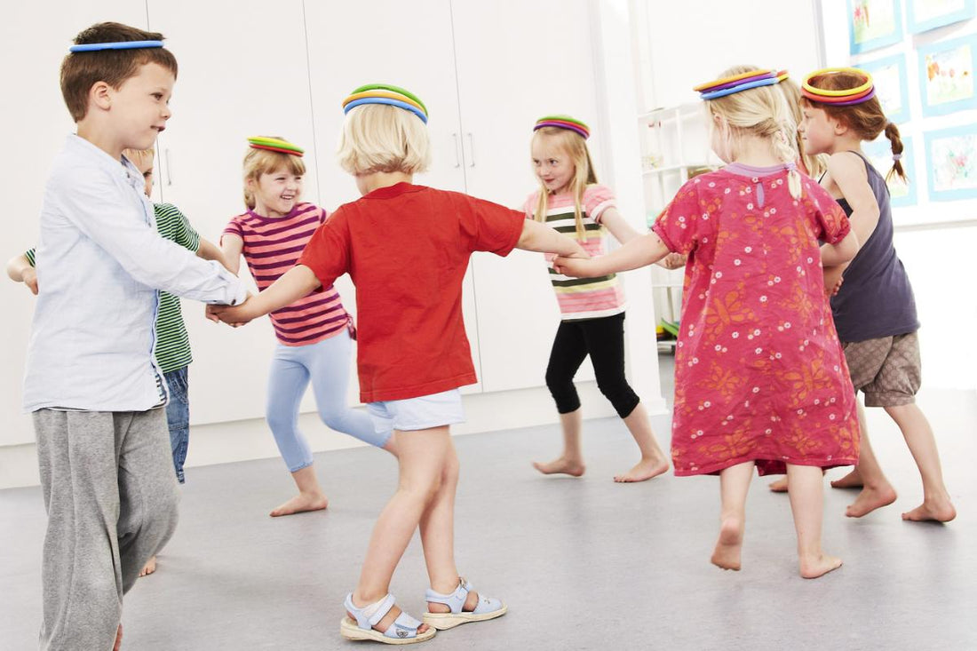 Groepje kinderen dat speelt met de regenboog ringen van Gonge. 