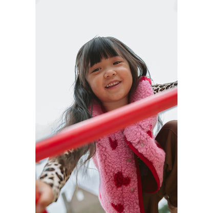Alwero X Salty Tyb Junior Bodywarmer Bubble in roze, gedragen door kind op speeltoestel, onderzicht.