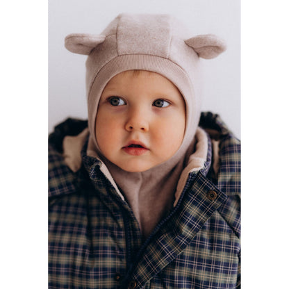 Wooly Organic balaclava in licht taupe met teddyoren, gedragen door peuter in geruit shirt - frontal portret