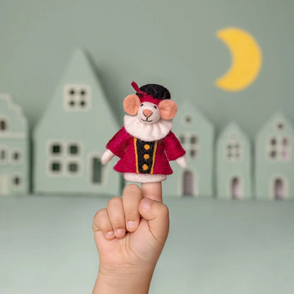 Pietermuis vingerpopje muis in cyclaamrood jurk op kindervinger, achtergrond met huisjes en maan