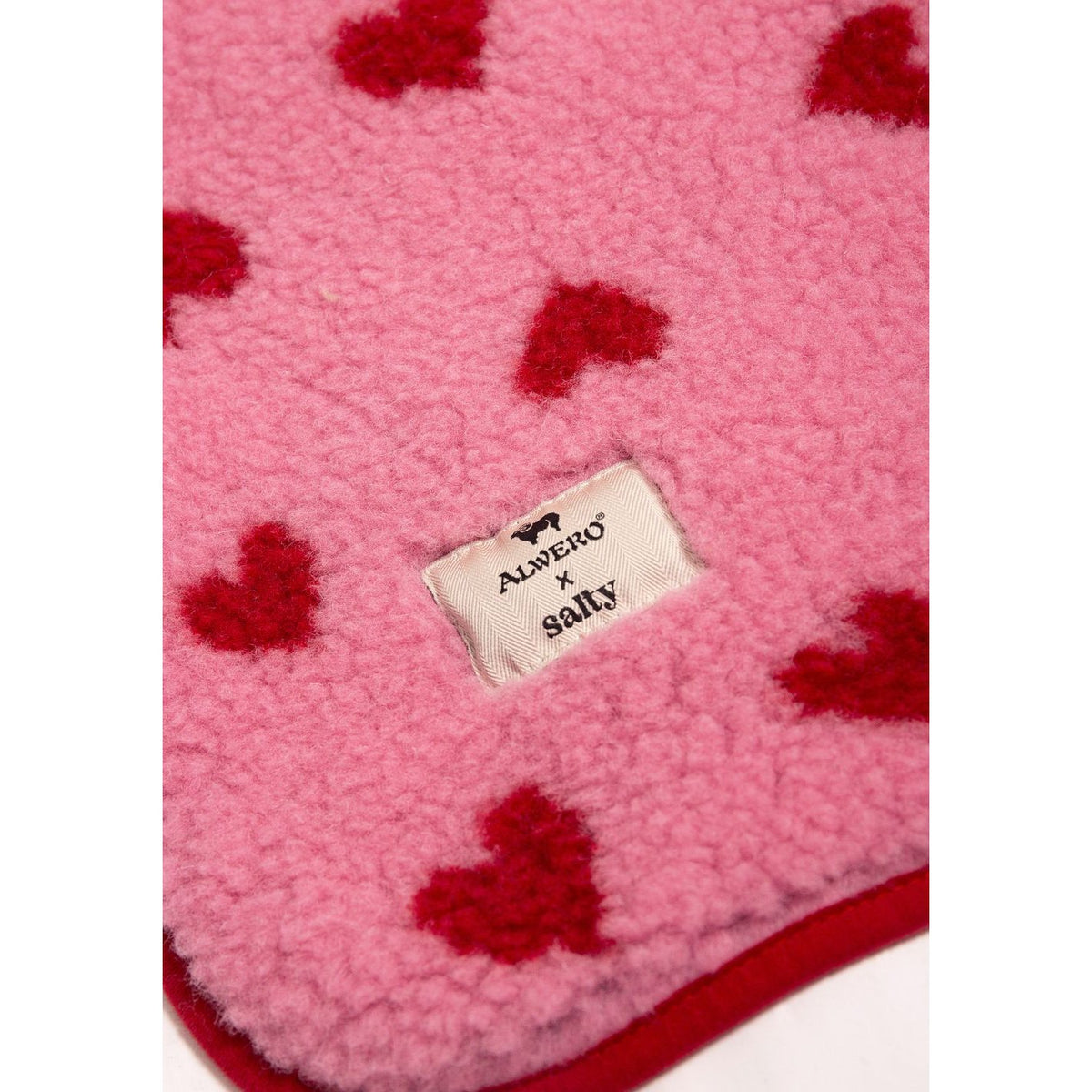 Alwero X Salty wollen deken in roze met rode hartjes patroon, close-up van label op textuur