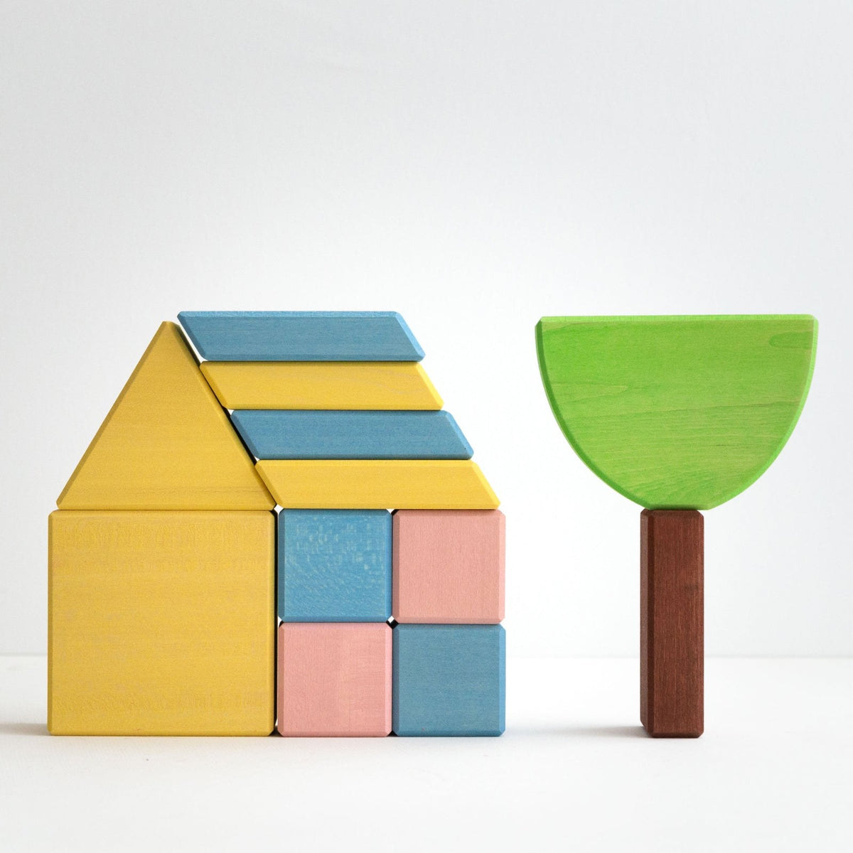 Avdar houten blokken set: geel huisje en groen boomfiguur naast elkaar op witte ondergrond