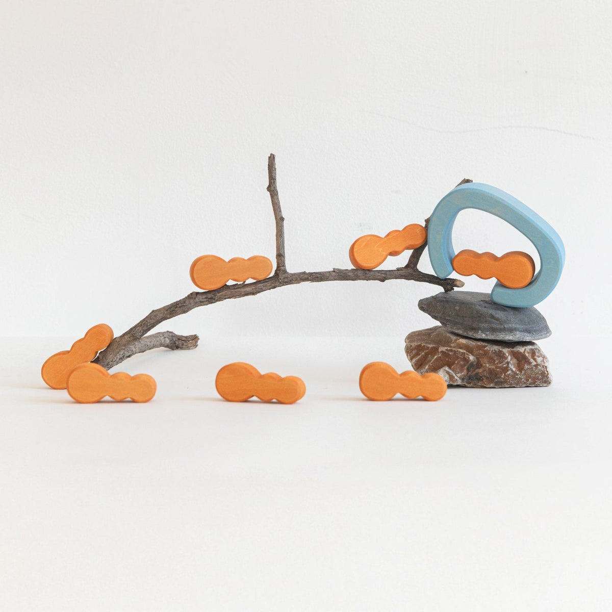 Avdar houten ant house blokken set: sculptuur van takken met oranje mierenfiguren en blauwe details op steenvoet