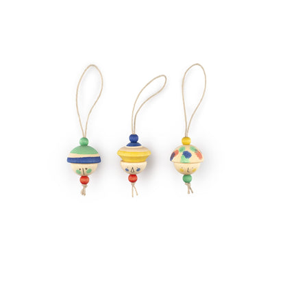 Drie houten hangers KIND FOLKS met poppenkoppen en gekleurde details op rij tegen witte achtergrond