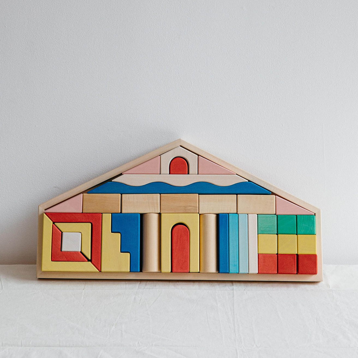Avdar houten blokkenset in huisvorm met gekleurde bouwblokken in rood, geel, blauw en groen vanaf voorkant gezien.