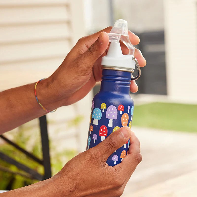 Klean Kanteen Classic 355ml sippy cup met kleurrijke paddenstoelenprint, gehouden in handen buiten
