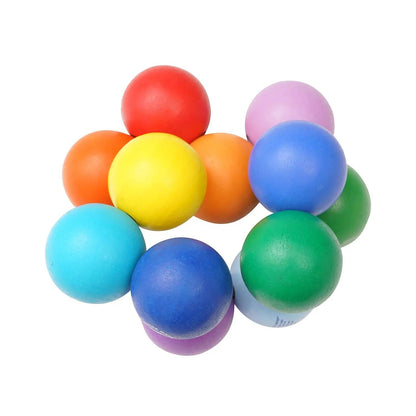 Manhattan Toy Classic Baby Beads: 10 gekleurde kralen in cirkelformatie, bovenaanzicht op witte achtergrond