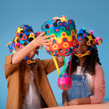Clixo Family Pack magnetisch bouwspeelgoed: kinderen houden gekleurde 3D-ballen omhoog tegen blauwe achtergrond