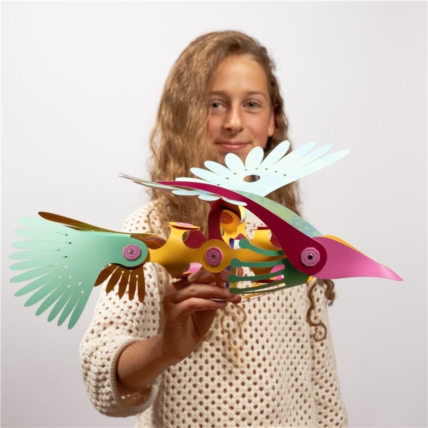 Meisje toont Clixo Tropical Birds Pack magnetisch bouwspeelgoed met gekleurde vogelfiguur met bewegende vleugels