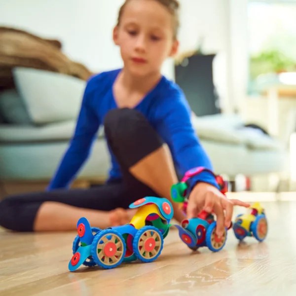 Clixo Wheel Creator Pack magnetische bouwset: kleurrijke flexibele onderdelen met wielen in gebruik door kind, vogelperspectief