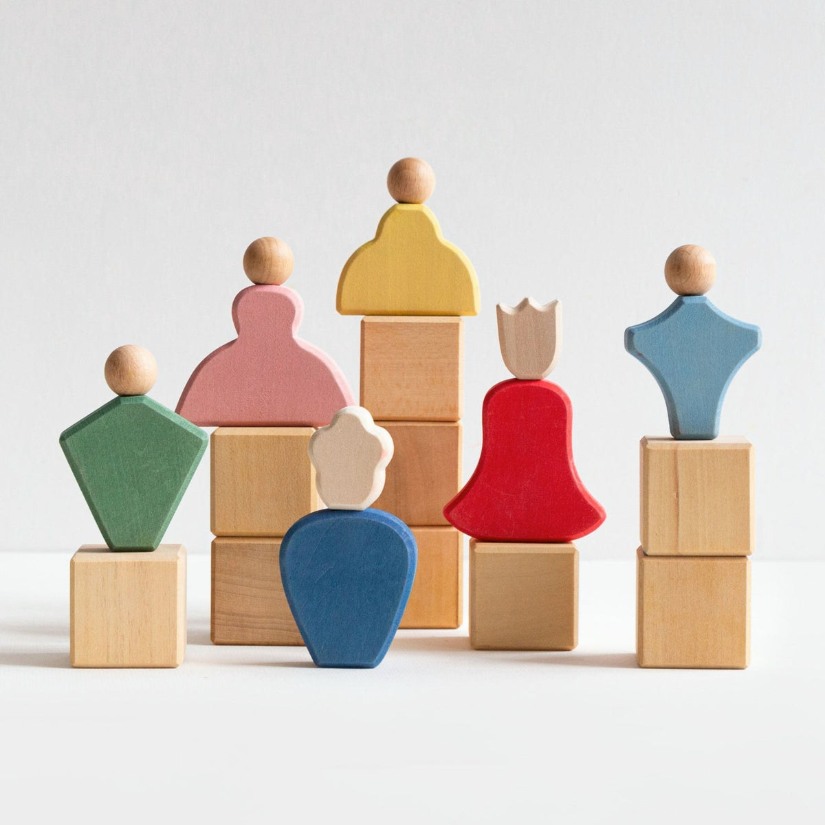 Avdar Fairytale Family houten figuren in groepsopstelling met gekleurde vormen op blokkentorens.