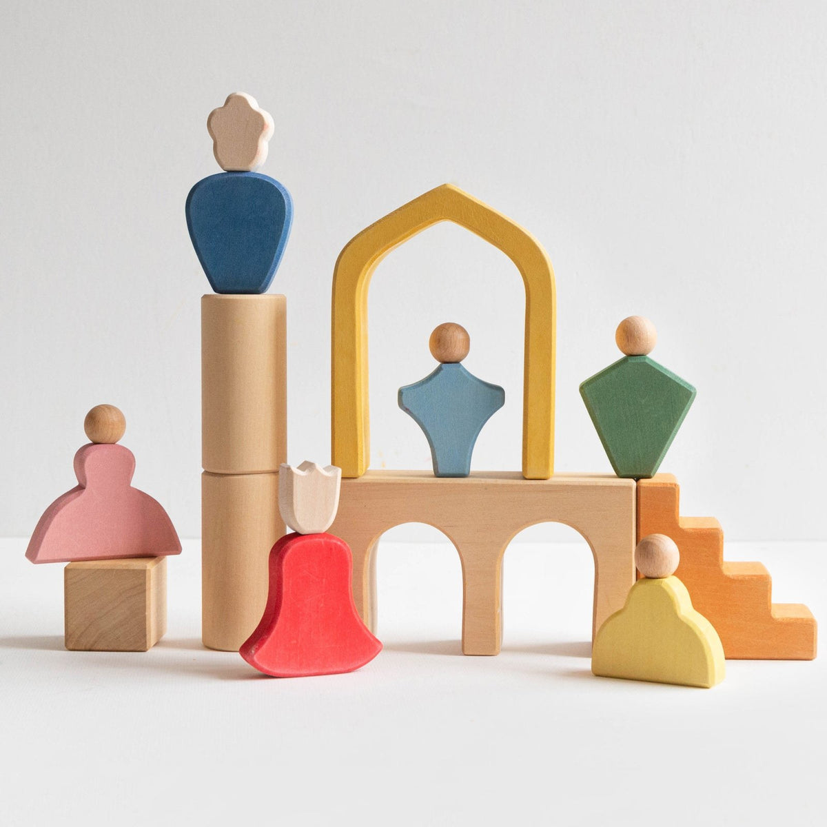 Avdar Fairytale Family speelset: zes gekleurde houten figuren in architectonische opstelling met kasteel en torens.