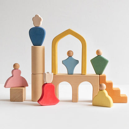 Avdar Fairytale Family speelset: zes gekleurde houten figuren in architectonische opstelling met kasteel en torens.