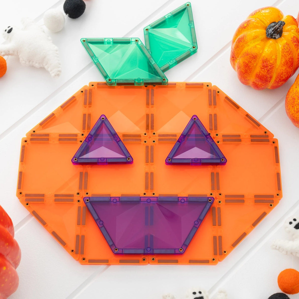 Connetix magnetische tegels Halloween Pumpkin Pack: pompoen-gezicht van oranje, paarse en groene tegels op witte achtergrond met decoratie.