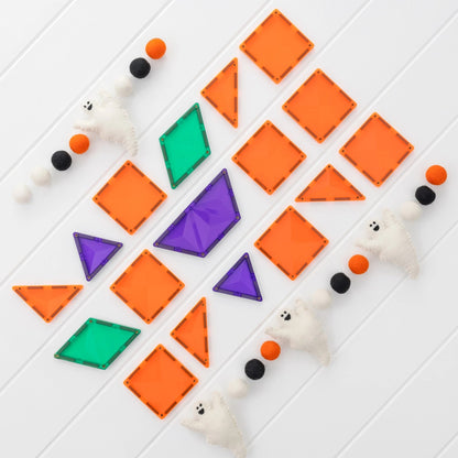 Connetix magnetische tegels Halloween set: oranje vierkanten en driehoeken, paarse en groene diamantvormen, witte speelfiguurtjes in diagonale opstell