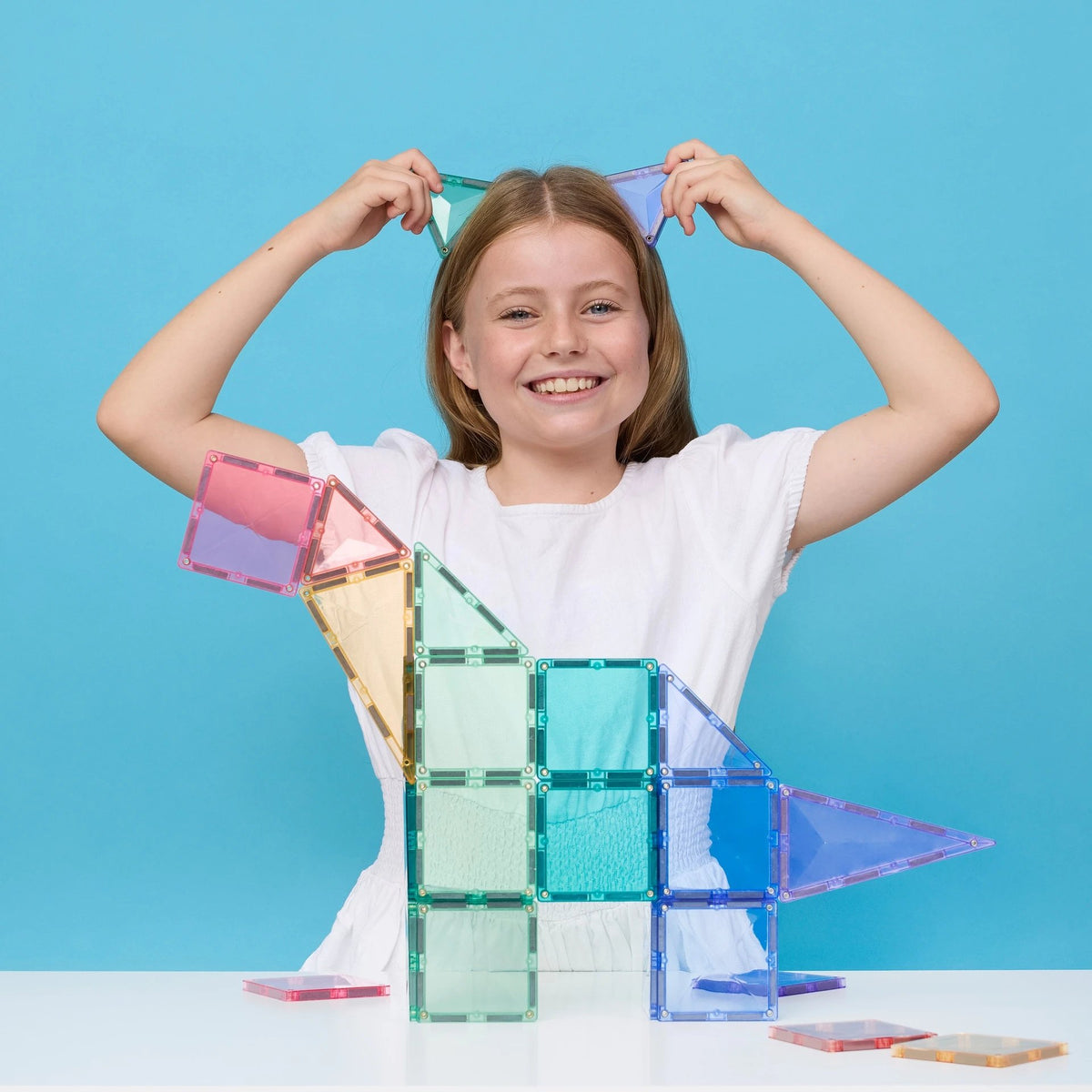 Meisje bouwt huisje met Connetix Tiles magnetische tegels in pastelkleuren