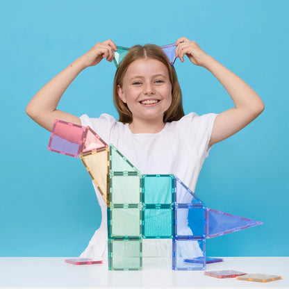 Meisje bouwt huisje met Connetix Tiles magnetische tegels in pastelkleuren