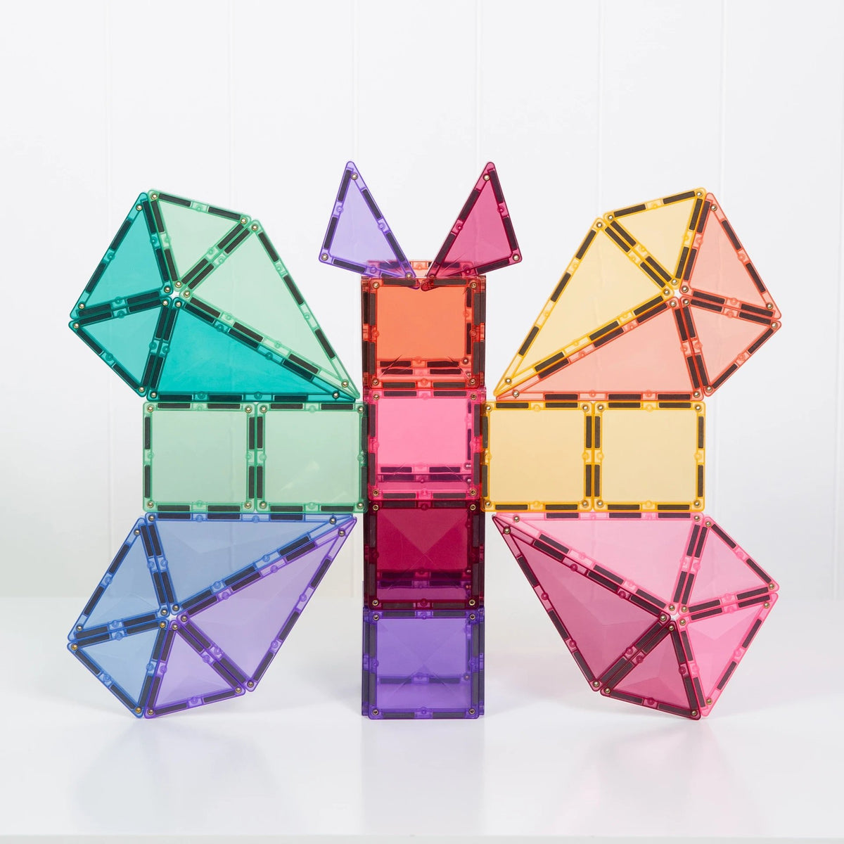 Connetix magnetische tegels in pastelkleuren: uitgebreide opstelling met huisvormen in het centrum en geometrische vormen aan zijkanten