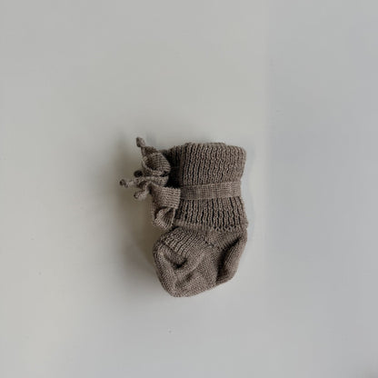 Hirsch Natur newborn sokjes in lichtgrijs wol, bovenaanzicht met strikdetail zijkant tegen witte achtergrond
