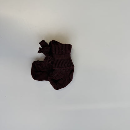 Hirsch Natur newborn sokjes in donkerbruin wol, van bovenaf gefotografeerd op witte achtergrond