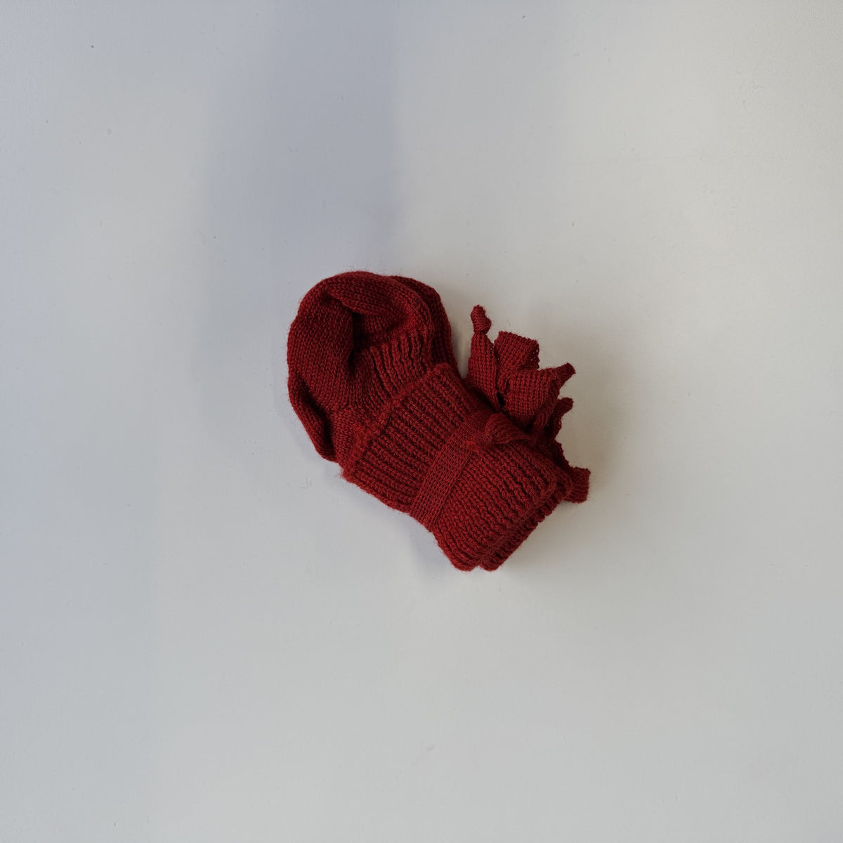 Hirsch Natur newborn sokjes in kersenrood, bovenaanzicht op witte ondergrond met details van de geribbelde structuur
