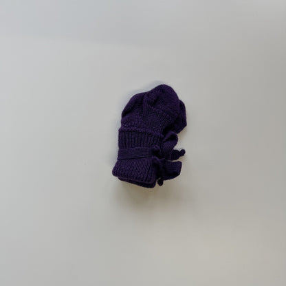 Hirsch Natur newborn sokjes in aubergine, opgerold op wit oppervlak in bovenaanzicht