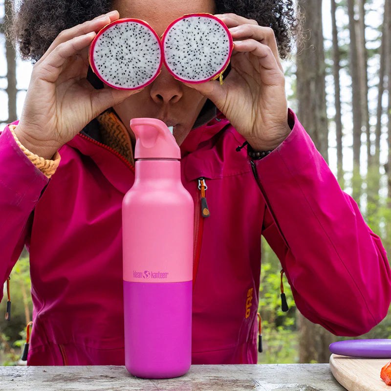 Klean Kanteen Rise Classic 473ml thermosfles in roze, gehouden voor ogen als verrekijker met drakenfruit halves