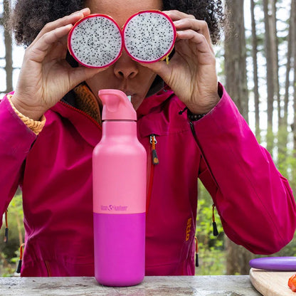 Klean Kanteen Rise Classic 473ml thermosfles in roze, gehouden voor ogen als verrekijker met drakenfruit halves