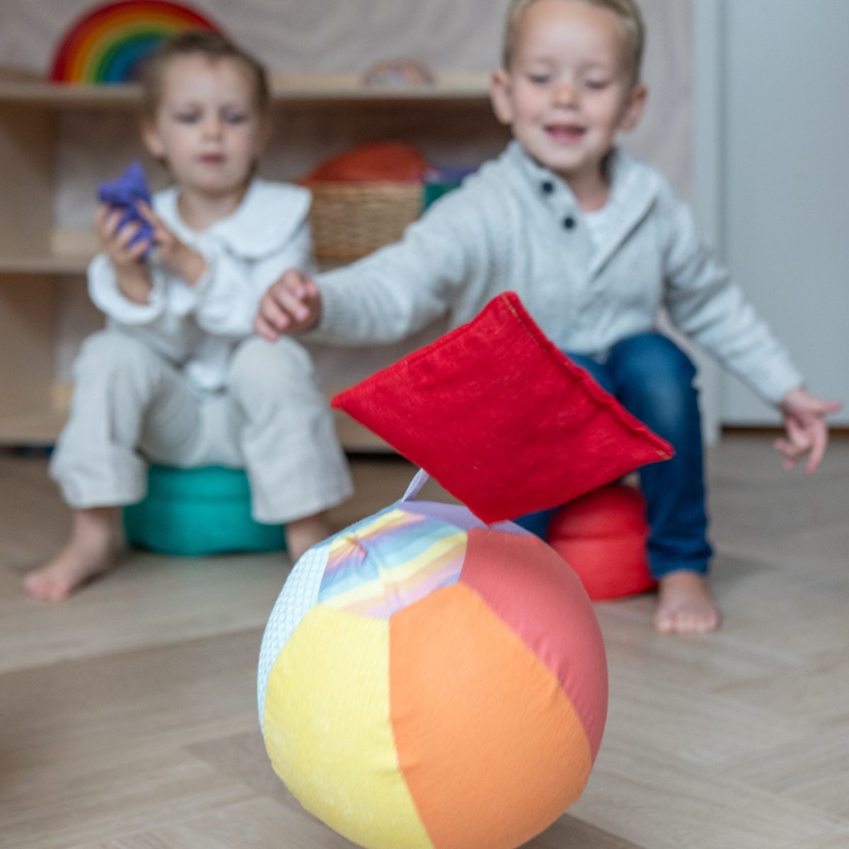 Little Botanic Label sensorische ballonbal in gebruik: twee peuters spelen in kinderkamer met gekleurde bal op voorgrond