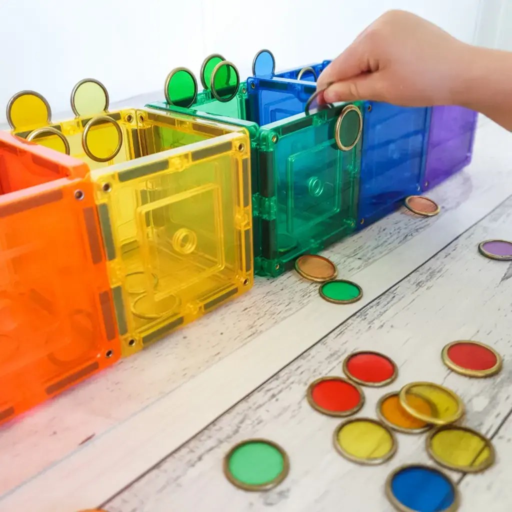 Learn and Grow Toys magnetische wand: kleurrijke transparante kringeltjes in stapelbare dozen met magnetische accessoires.