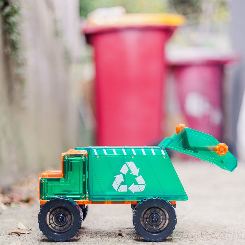 Learn & Grow magnetische recycling truck speelgoed op straat, groen met wit recyclesymbool en oranje details, vooraanzicht met uitklapbare afvalbak.