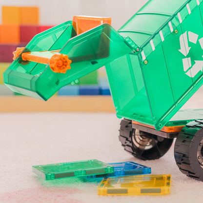 Learn & Grow magnetische afvaltruck met beweegbare arm pakt gekleurde tegels op, vooraanzicht met losse tegels op tafel