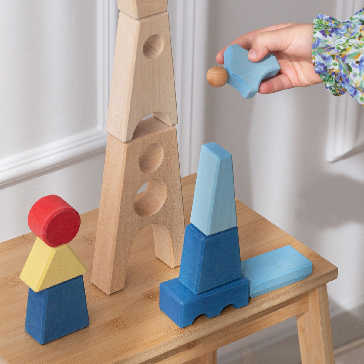 Avdar Maxi Castle houten blokken set met kleurrijke bouwstenen in blauw, geel en rood, kind plaatst blok op toren