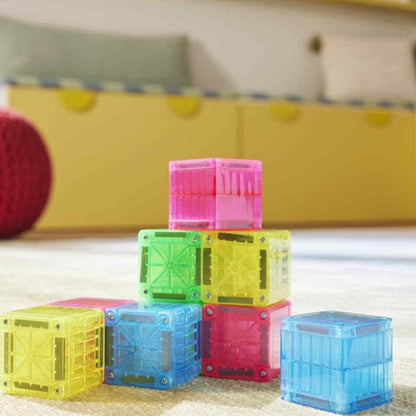 Magna-Tiles microMAGS magnetische kubussen in geel, roze en blauw gestapeld op speelmat