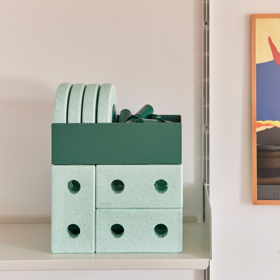 MODU 3-in-1 baby walker in ocean mint en forest green op een wit schap, voorkant weergave met opbergvak