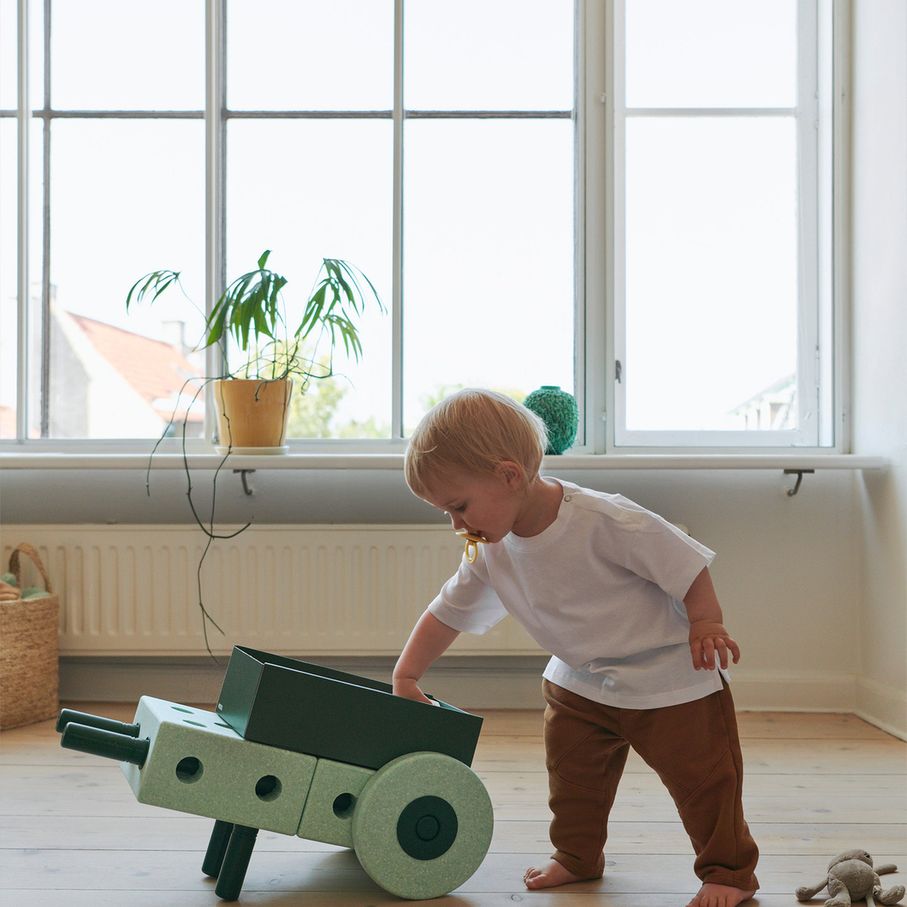 MODU 3-in-1 baby walker in ocean mint en forest green gebruikt door peuter in licht interieur met grote ramen