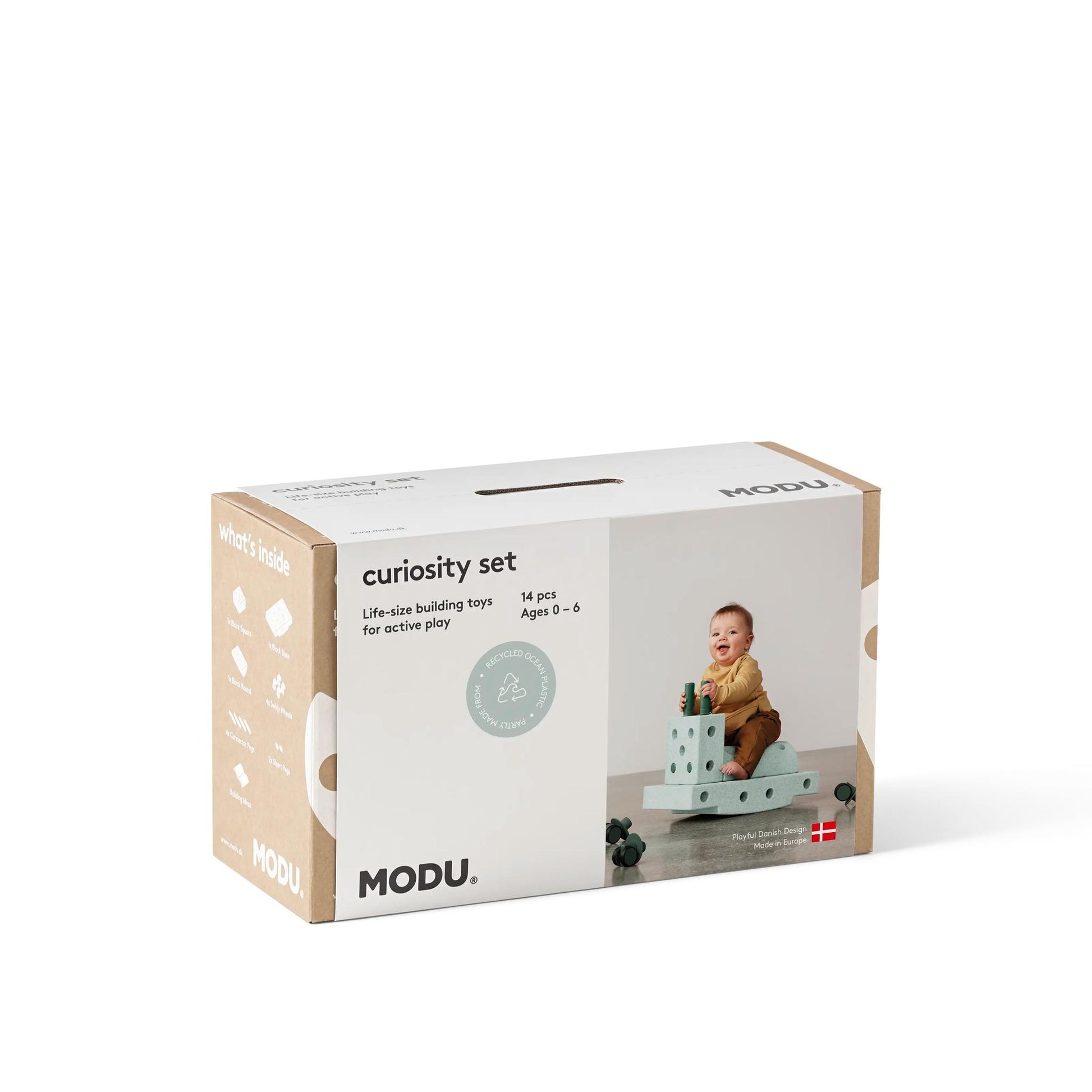 MODU Curiosity Set bouwblokken verpakking met baby spelend op modulair speelgoed