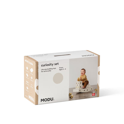 MODU Curiosity Set bouwspeelgoed verpakking met foto van peuter spelend met houten blokken, vooraanzicht tegen witte achtergrond