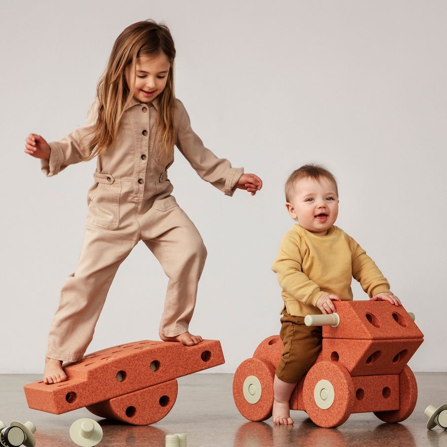MODU Dreamer Set: twee kinderen spelen met burnt orange bouwblokken, oudste kind balanceert op wip, jongste zit op wieltjes module