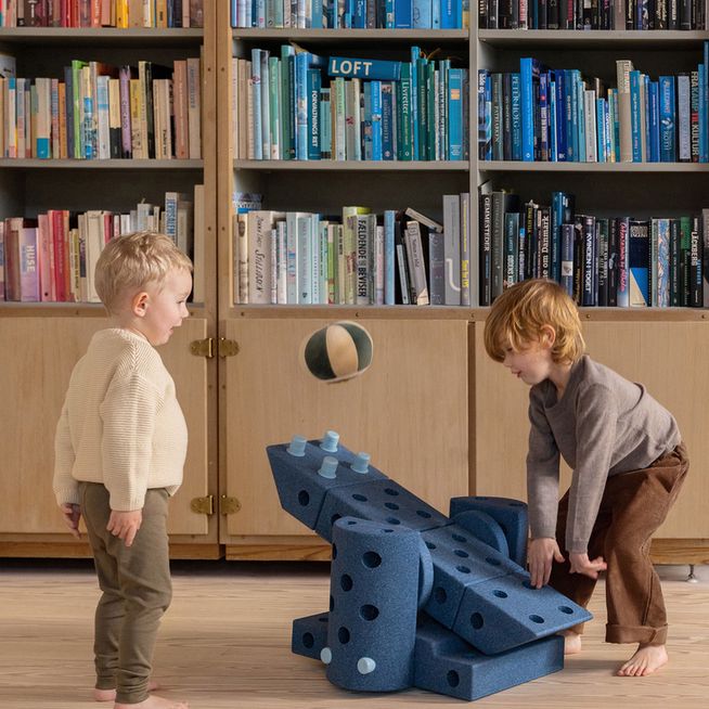 MODU Dreamer Set bouwspeelgoed in deep blue: twee kinderen spelen in een huisachtige constructie in een bibliotheekruimte