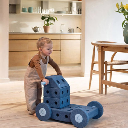 MODU Dreamer Set Deep Blue bouwspeelgoed: peuter speelt met blauwe schuimblokken en wielen in moderne woonkamer