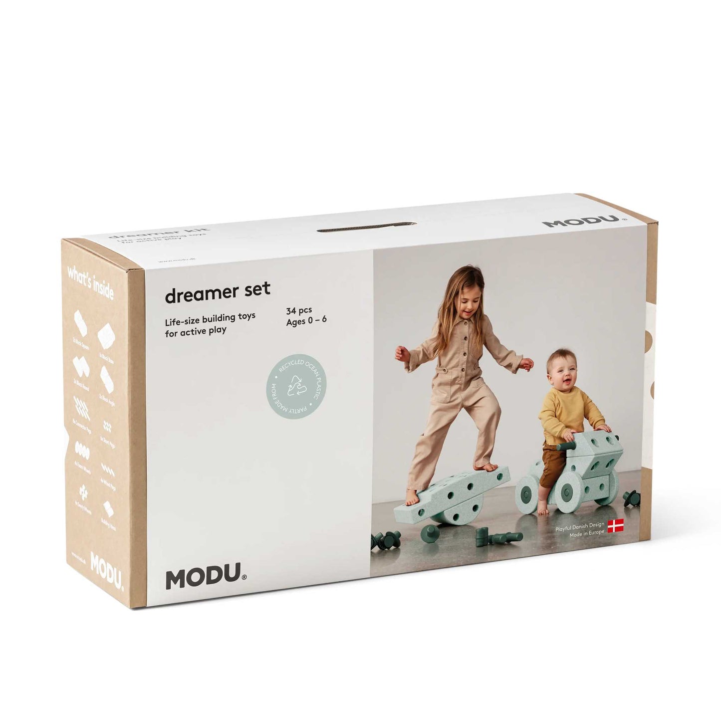 MODU Dreamer Set bouwblokken verpakking met twee kinderen spelend op groen modulair bouwsysteem, vooraanzicht van doos