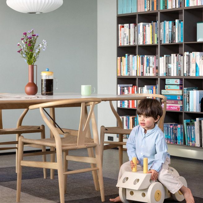 MODU Dreamer Set speelgoedblokken in gebruik: peuter zit op zelfgebouwd rollerspeelgoed in interieur met boekenkast