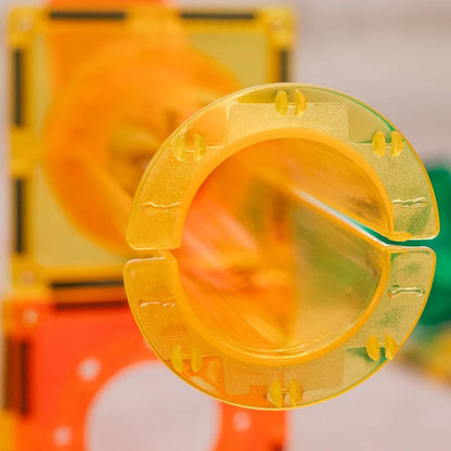Learn and Grow Toys magnetische ballrun - gele spiraal buisbocht close-up tegen oranje bouwstenen achtergrond