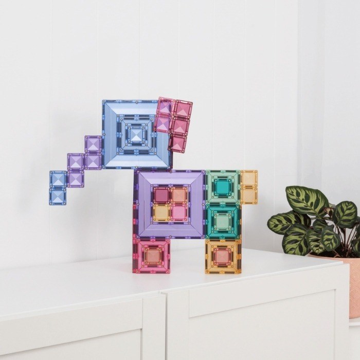 Connetix magnetische tegels in pasteltinten opgesteld in 3D-constructie op wit oppervlak, met blauwe, paarse, roze, groene en gele portaaltegels