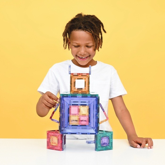 Kind speelt met Connetix magnetische tegels in pastelkleuren, bouwt 3D-structuur met gekleurde portaalbouwstenen