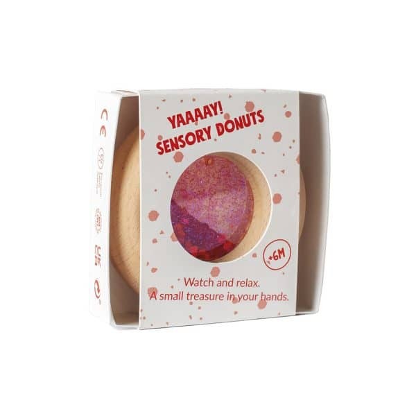 Petit Boum sensorische donut in rood met glitters, verpakt in witte doos met rood spetterpatroon, vooraanzicht van de verpakking.